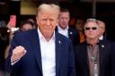 Republican presidential candidate and former President Donald Trump, left, gestures as he arrives at the Miami Formula One Grand Prix auto race Sunday, May 5, 2024, in Miami Gardens, Fla. (AP Photo/Rebecca Blackwell)