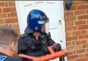 IMPACT: An officer uses an enforcer to break open a door in Evesham
