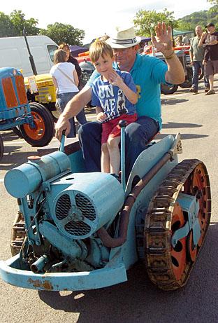 Nathan Williams, five, takes a ride on a 1936 Ransom Crawler NG2 driven by Keith Chandler