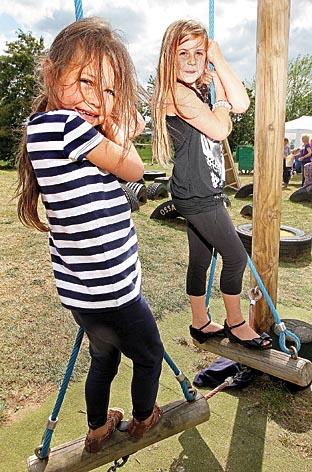 Lola Harrison, five, and Elise Taylor, eight, swing on the rope climbing frame at Offenham First School.