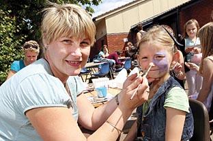 Melissa Tomes, six, has her face painted by Claire Johnson-Malvern.
