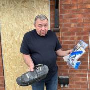 AFTERMATH: Terry Harrison holding the remains of his Hoodrich sandles and PS4 games wrecked by the police chainsaw raid in Canterbury Road in Ronkswood