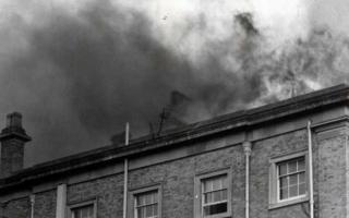 Flames and smoke can be seen rising from the roof of Hindlip Hall as police officers dash to rescue documents