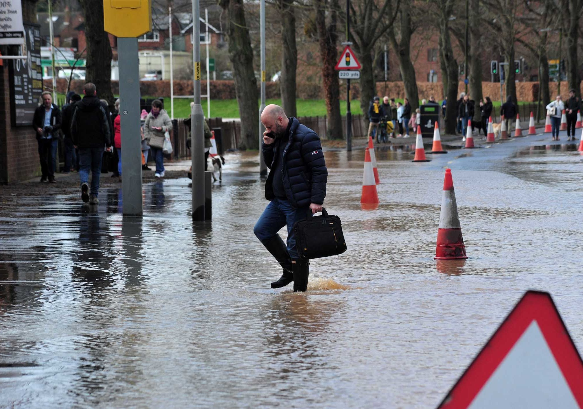 I WILL GET TO WORK: A pedestrian wades across New Road