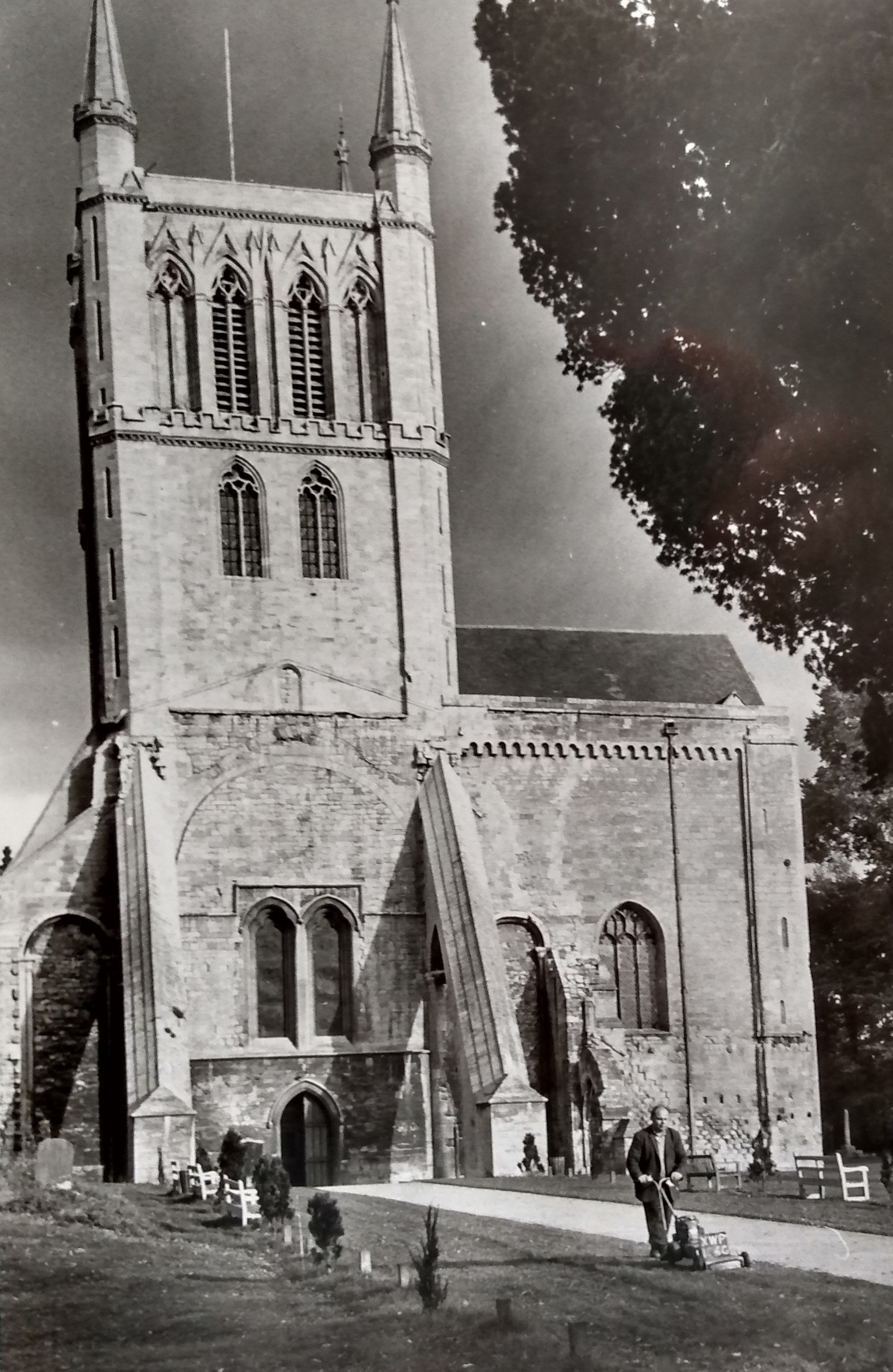 Mowing the verges in this eye-catching portrait of Pershore Abbey, sadly undated