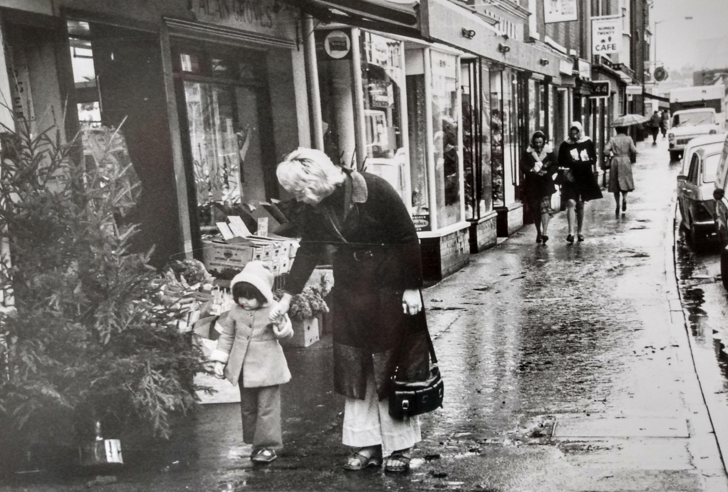 Late November 1976 and Christmas shopping is proving a damp affair - bit early to be putting the tree up