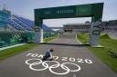 A worker paints Olympic rings at the finish line of the BMX racing track as preparations continue for the 2020 Summer Olympics, Tuesday, July 20, 2021, at the Ariake Urban Sports Park in Tokyo. (AP Photo/Charlie Riedel).