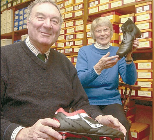 Inside E H Spencer in 2002, Margaret Rutter with toe-capped football boots from 40 years ago, and husband Keith with a modern one